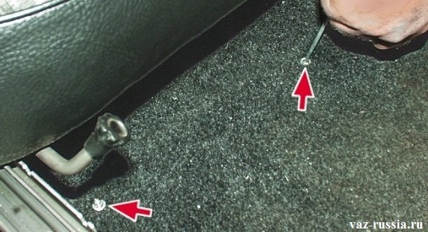 Отворачивание винта крепления коврика передней части автомобиля